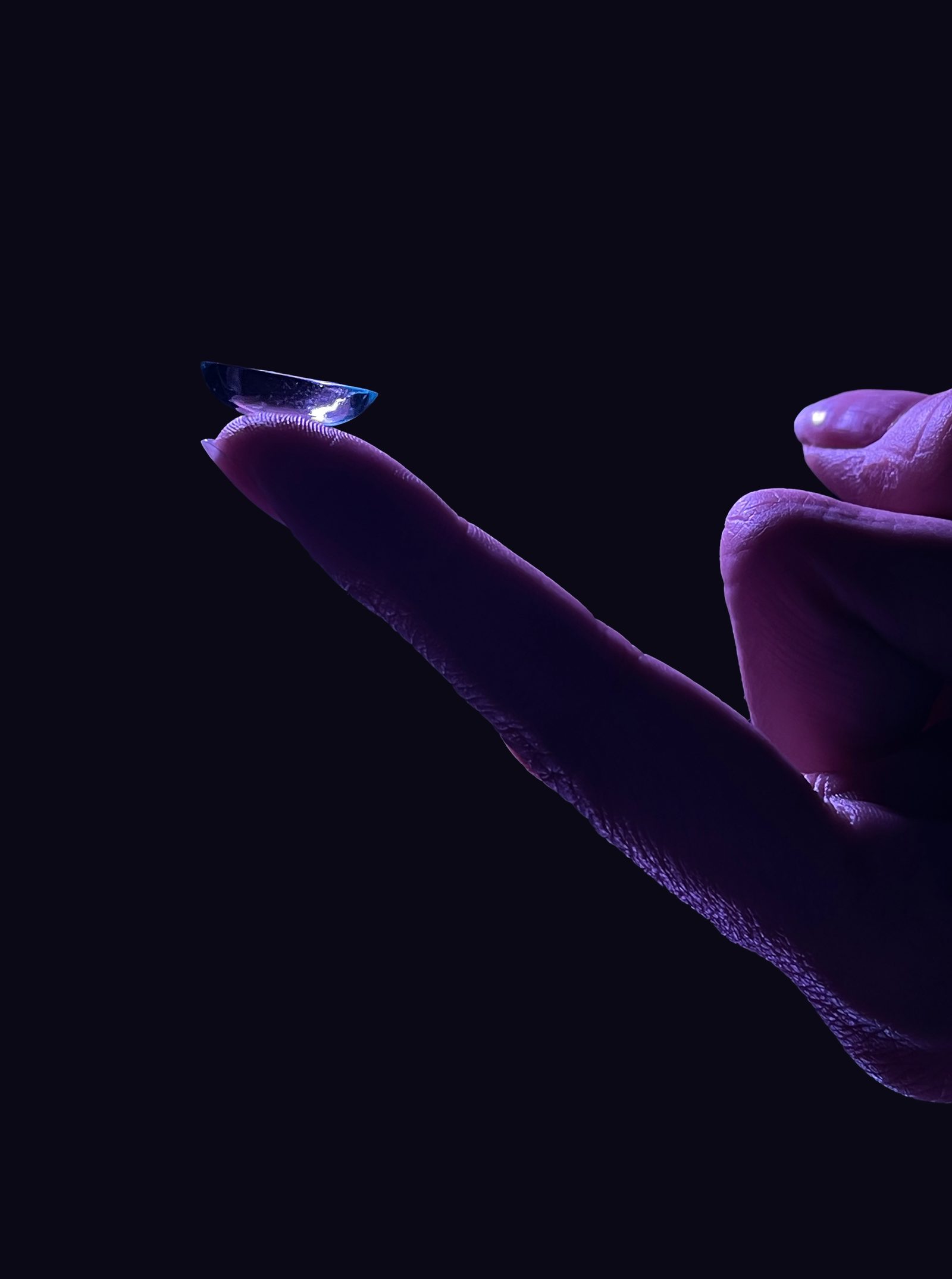 Single finger with EDEN lens balanced on fingertip