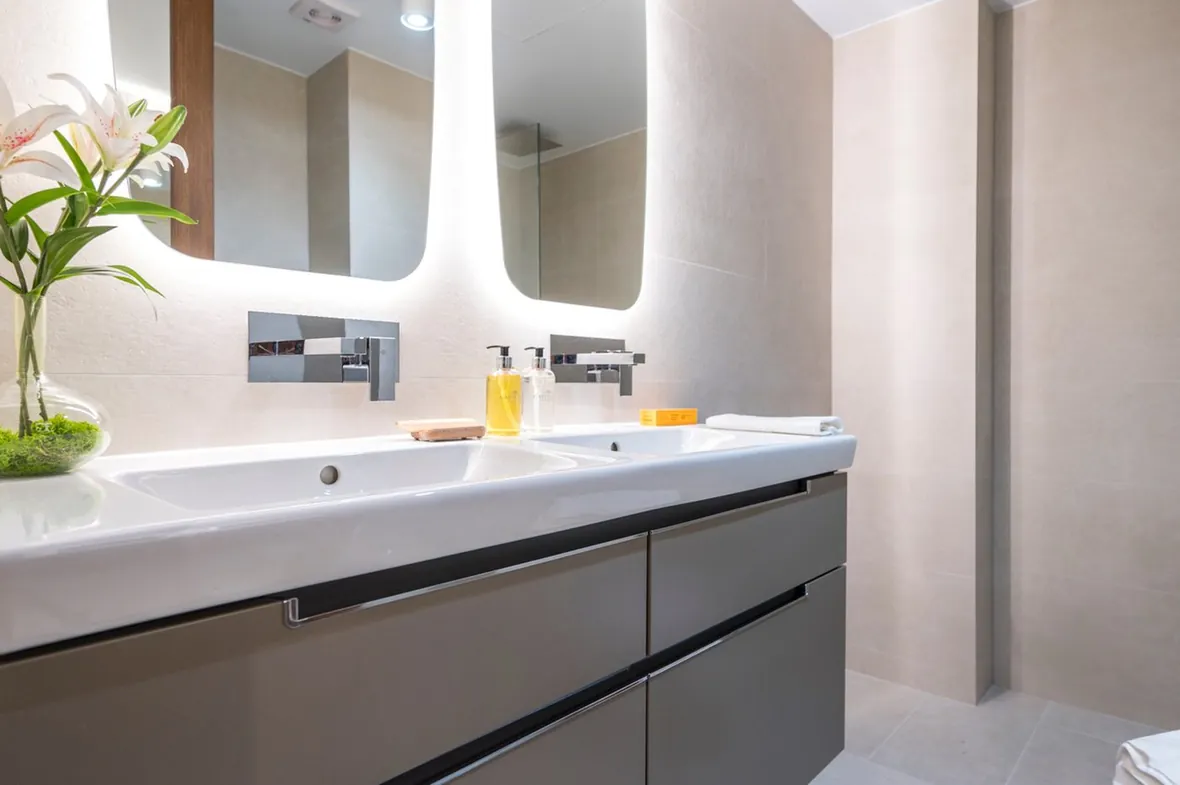 Baño moderno con espejos retroiluminados